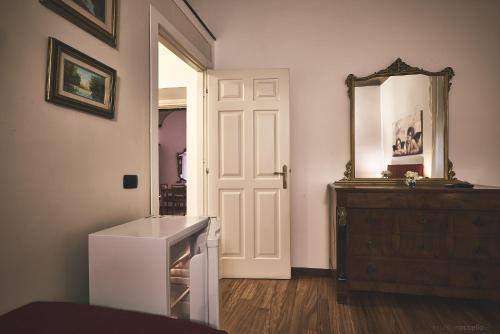 a white room with a mirror and a dresser at Affittacamere San Teodoro in Albenga