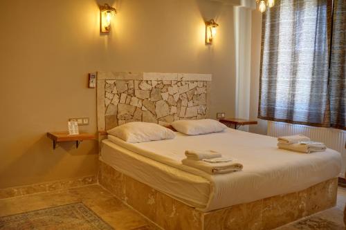 a bedroom with a bed with two towels on it at Ala Stone House in Goreme