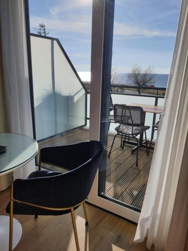 a room with a balcony with a table and chairs at Haus Achtern Diek in erster Reihe am Meer in Fehmarn