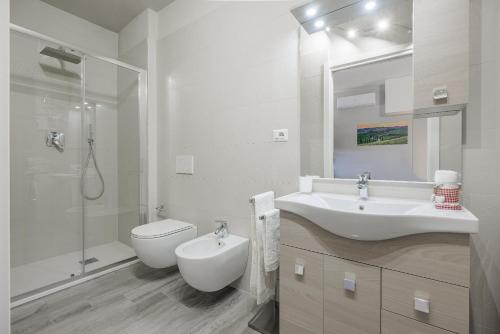 a white bathroom with a sink and a toilet at Siena Living Apartment in Siena