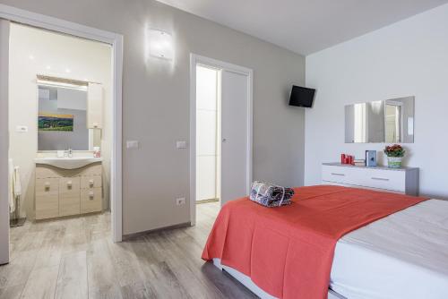 a bedroom with a bed with a red blanket and a sink at Siena Living Apartment in Siena