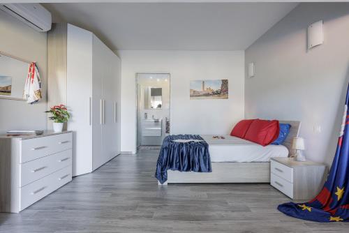a white bedroom with a bed and a bathroom at Siena Living Apartment in Siena