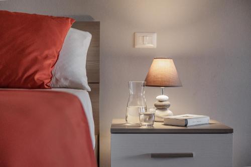 a bed with a lamp on a nightstand next to a bed at Siena Living Apartment in Siena