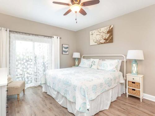 a bedroom with a bed and a ceiling fan at Bay View Villas 105 in Tybee Island