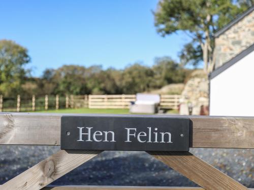 a sign on a wooden bench that reads hen featherin at Hen Felin in Pwllheli