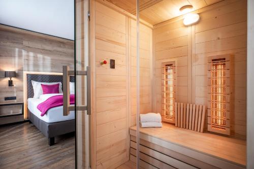 sypialnia z łóżkiem i szklanymi drzwiami w obiekcie Hotel Adapura Wagrain w mieście Wagrain