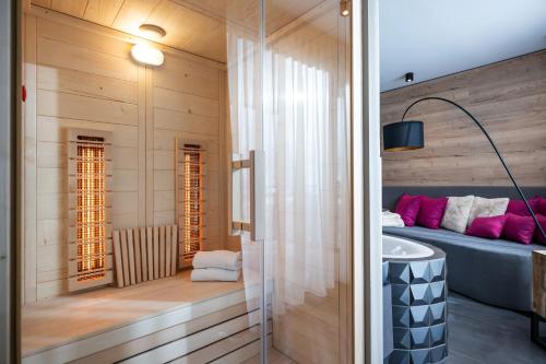 łazienka z łóżkiem i umywalką w pokoju w obiekcie Hotel Adapura Wagrain w mieście Wagrain