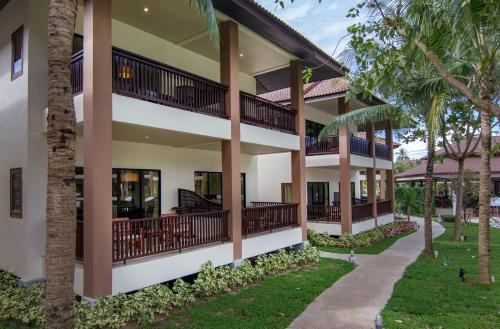 a view of the outside of a building with palm trees at The Leaf Oceanside by Katathani - SHA Extra Plus in Khao Lak
