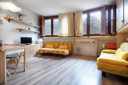 salon z żółtymi krzesłami i biurkiem w obiekcie Condominio Escargot w mieście Breuil-Cervinia