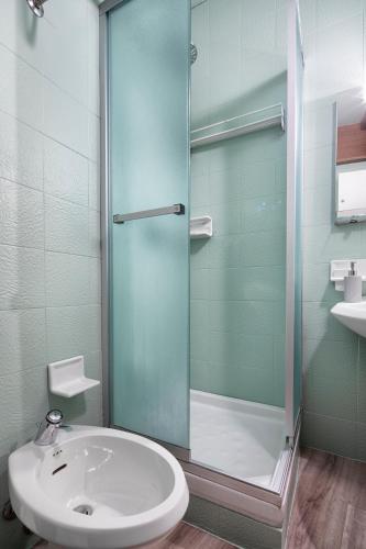 a bathroom with a glass shower and a sink at Condominio Escargot in Breuil-Cervinia