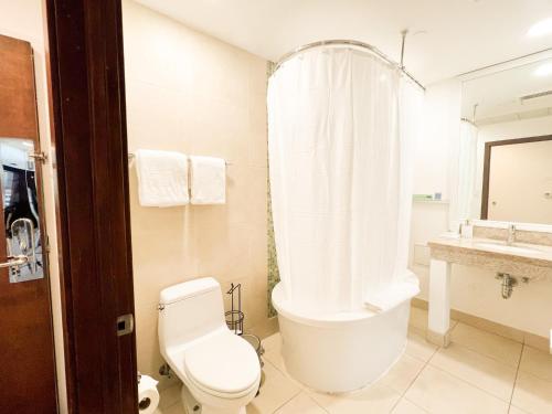 a bathroom with a tub and a toilet and a sink at Rooftop-Pool Suite with King Bed in Ocean Dr C303 in Miami Beach