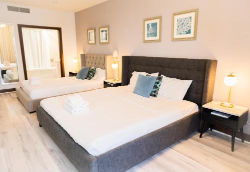 two beds in a room with two lamps and a bed sidx sidx sidx at Rooftop-Pool Suite with King Bed in Ocean Dr C303 in Miami Beach