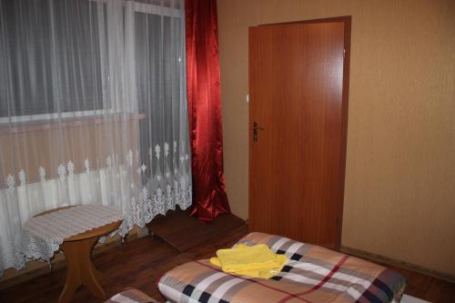 a room with a bed and a table and a door at Gospodarstwo Agroturystyczne Agroletnica in Świdnica