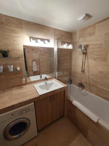 ein Badezimmer mit einem Waschbecken und einer Waschmaschine in der Unterkunft Villapark Pleasure Apartment in Balatonfüred