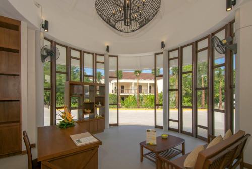 a room with large windows and a table and chairs at The Leaf Oceanside by Katathani - SHA Extra Plus in Khao Lak