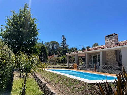 a swimming pool in the backyard of a house at La Elina in Villa General Belgrano