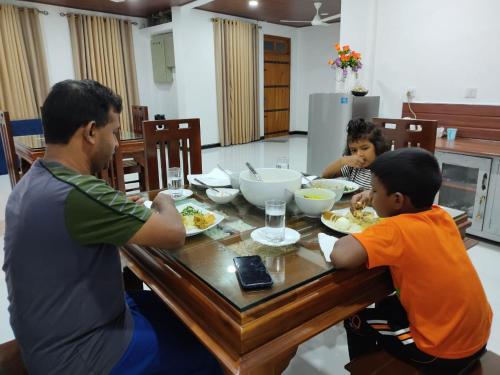 a group of people sitting at a table eating food at Enara Luxury Stay in Katugastota
