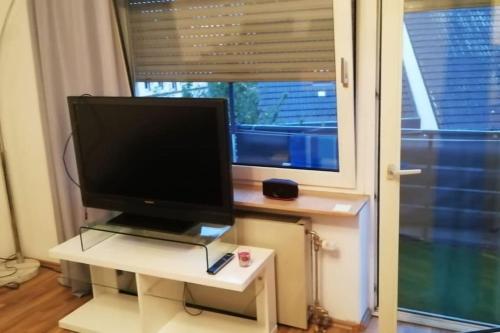 einen Fernseher, der auf einem weißen Tisch vor einem Fenster sitzt in der Unterkunft Nice and cozy 1 room apt in Wiesbaden