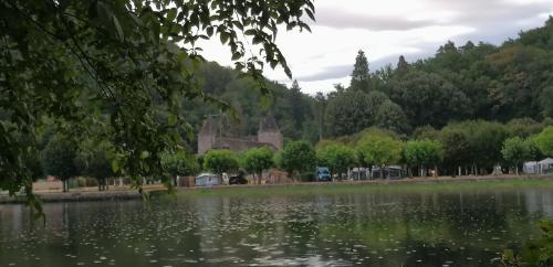 a view of a lake with a house in the background at GITE DOUSTRET in Argentat