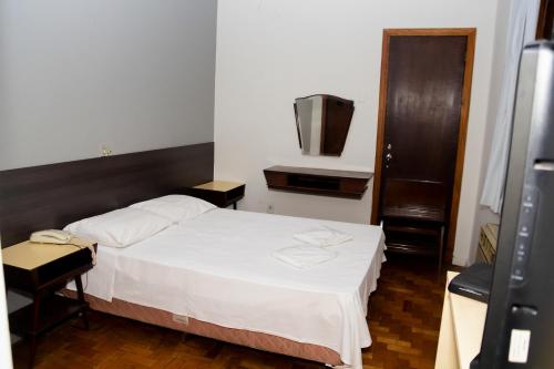 a small bedroom with a bed and a television at Amazonas Palace Hotel Belo Horizonte - By UP Hotel - Avenida Amazonas in Belo Horizonte