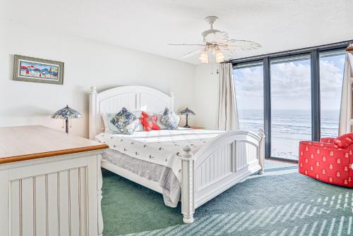 a bedroom with a white bed and a large window at Sand Dollar II 408 in Saint Augustine