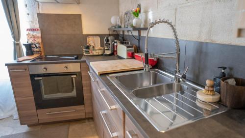 a kitchen with a stainless steel sink and a stove at Duplex calme et climatisé au Centre historique in Avignon