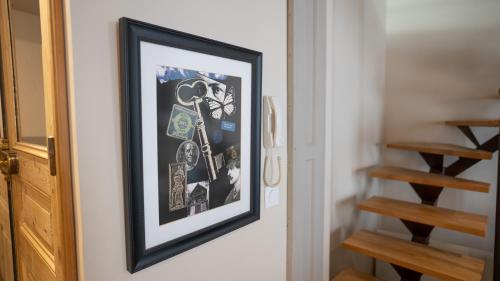 a framed picture hanging on a wall in a hallway at Duplex calme et climatisé au Centre historique in Avignon