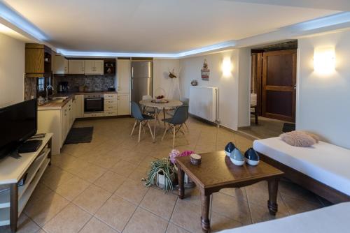 Una cocina y una sala de estar con una mesa y un sofá. en Stilvi, en Tsagkarada