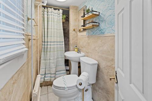 a bathroom with a toilet and a sink at Tropical Bohemian 1BR Apt near Atlantic City Beach in Atlantic City