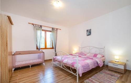 Schlafzimmer mit einem rosa Bett und Holzboden in der Unterkunft Awesome Home In Biograd Na Moru With House A Panoramic View in Biograd na Moru