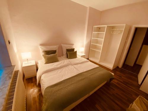 a small bedroom with a bed and two lamps at Tolle Stadtwohnung mit guter Verkehrsanbindung Von der Goltz 35 in Dortmund