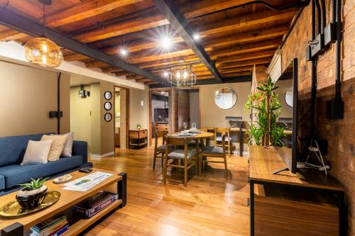 a living room with a blue couch and a table at Nido Roma Norte in Mexico City