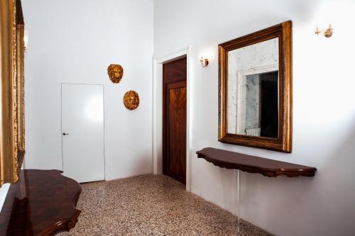 a mirror on a wall next to a hallway at Cà Mascaròn in Venice
