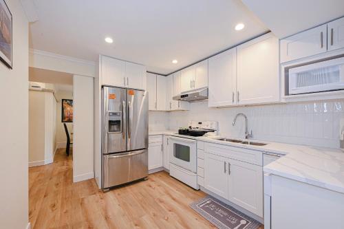 a kitchen with white cabinets and a stainless steel refrigerator at Quite House near the Vancouver Airport in Richmond