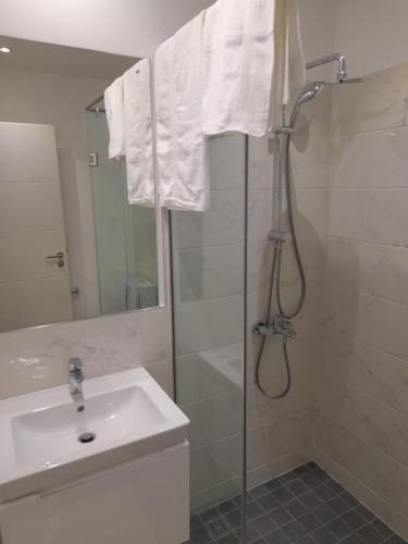 W łazience znajduje się prysznic i umywalka. w obiekcie The Lennox D-Plus Apartments w Akrze