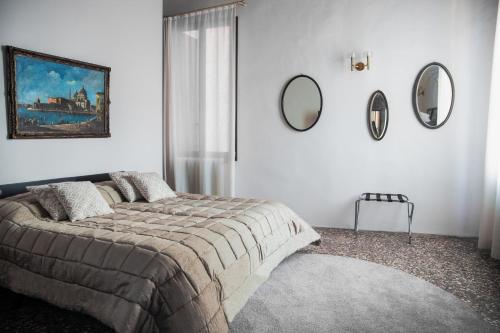 Schlafzimmer mit einem Bett und Spiegeln an der Wand in der Unterkunft Cà Mascaròn in Venedig