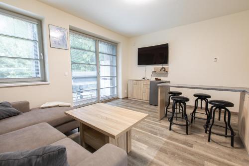 a living room with a couch and a table at Apartmány pod Zakletým - Hotel Říčky in Říčky