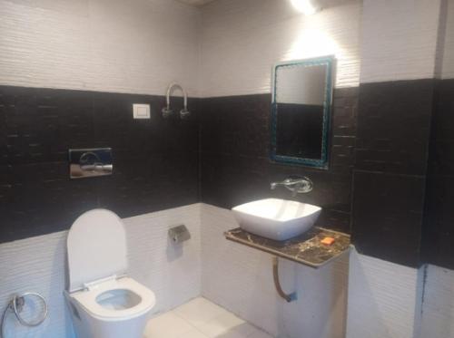 a bathroom with a white toilet and a sink at Him Taj by StayApart in Manāli