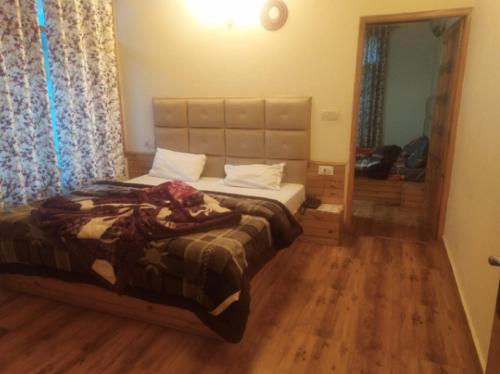 a bedroom with a bed and a mirror at Him Taj by StayApart in Manāli