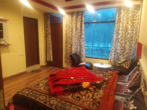 a bedroom with a bed and a large window at Him Taj by StayApart in Manāli