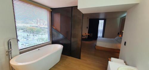 a bathroom with a bath tub and a bedroom at Autentico Monterrey in Monterrey