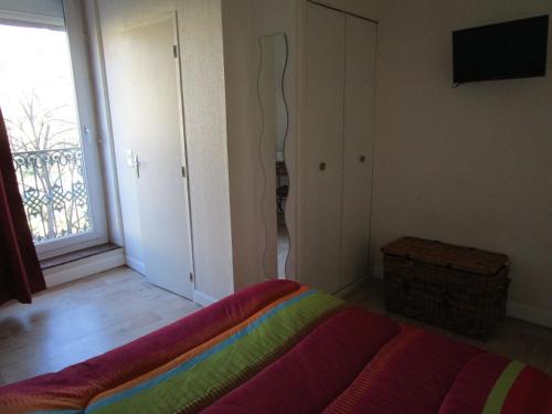 a bedroom with a bed and a window and a television at Hôtel Des Poètes avec parking sur réservation in Béziers