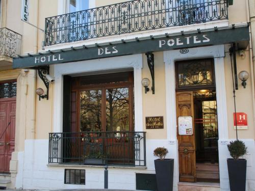 a store with a balcony on the front of a building at Hôtel Des Poètes avec parking sur réservation in Béziers