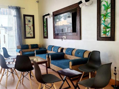 salon z niebieską kanapą i krzesłami w obiekcie Solitude, The Boutique Hotel w mieście Haldwani