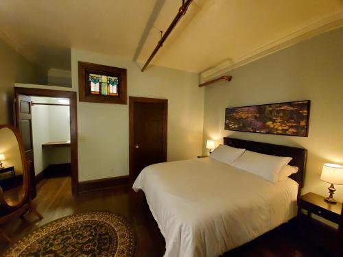 a bedroom with a large white bed and a window at Daniell Manor in Laurium