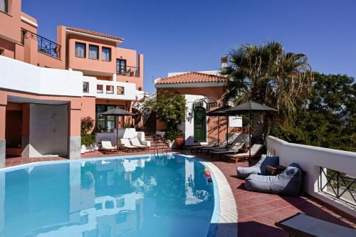 a swimming pool in front of a house at Nisea Hotel Samos in Pythagoreio