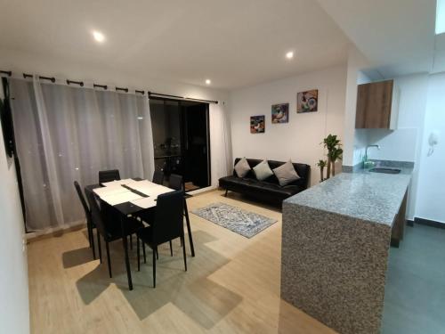 a kitchen and living room with a table and a couch at Apartamento en zona norte bogota in Bogotá