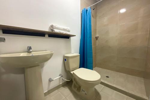 a bathroom with a toilet and a sink and a shower at Hotel Andina Blue Santa Marta in Santa Marta