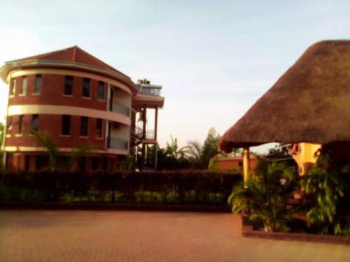 een groot bakstenen gebouw met een rieten dak bij Nile Bridge Cottages in Jinja