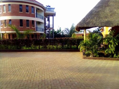 a building with a brick driveway in front of a building at Nile Bridge Cottages in Jinja